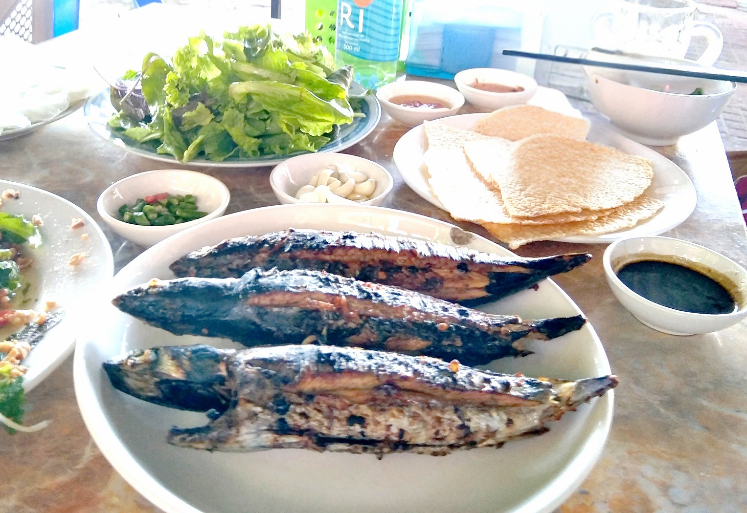 Cá ồ tháo giấy bạc ra nướng trần trên lửa than. Ảnh: MẠNH HOÀI NAM